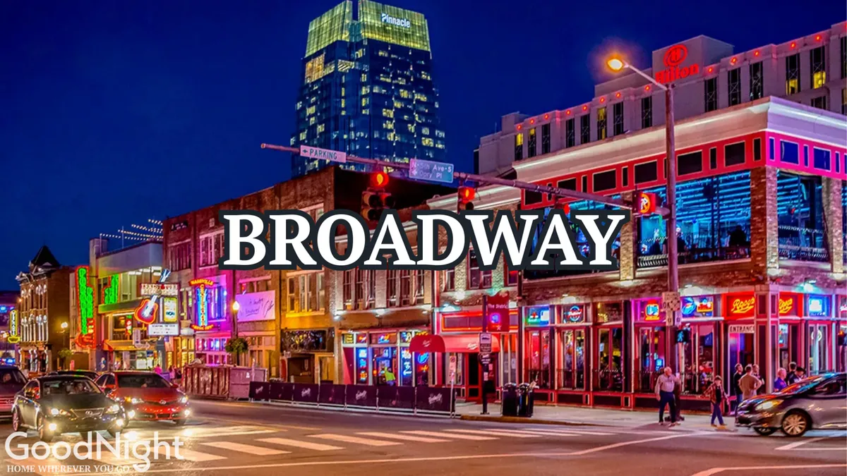 A lively Nashville street scene at dusk, featuring bright neon signs, bustling sidewalks, and a mix of restaurants and music venues. People are seen dining, walking, and enjoying the energy, with tall buildings and a vibrant city atmosphere in the background.